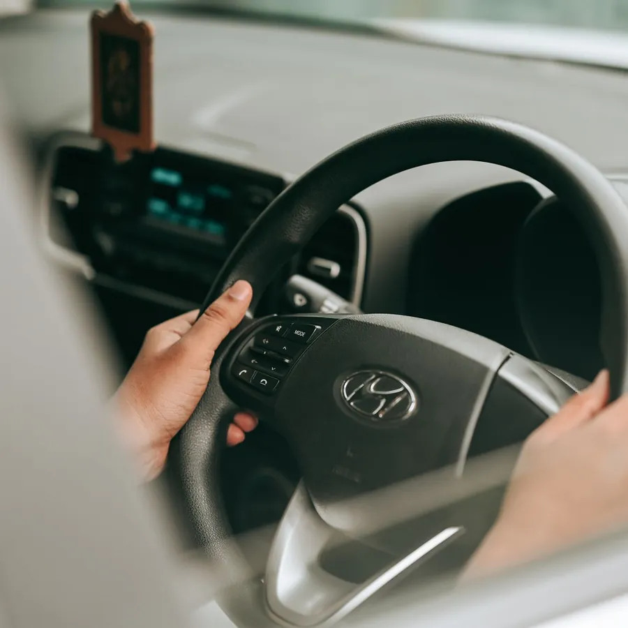 Mains sur le volant pendant l'essai routier d'une voiture d'occasion