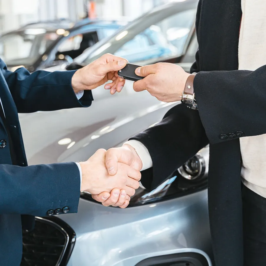 Remise des clés après négociation du prix d'une voiture d'occasion